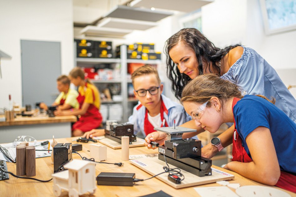 Students and teacher work with the UNIMAT ML jig saw in a workspace